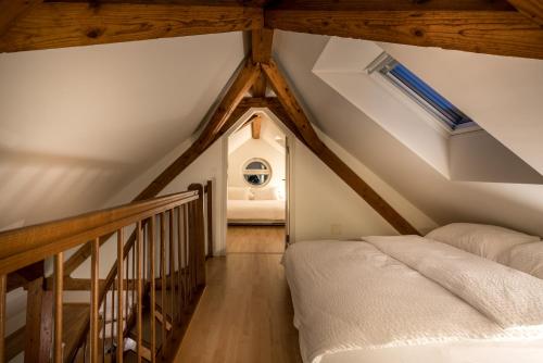 a attic bedroom with a bed and a staircase at Airhome Zug Neugasse Stadtzentrum in Zug