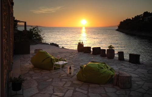 a sunset over a body of water with a table and chairs at 4 Bedroom Gorgeous Home In Korcula in Korčula