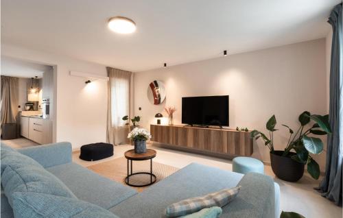 a living room with a blue couch and a tv at 4 Bedroom Gorgeous Home In Korcula in Korčula