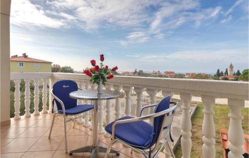 d'un balcon avec deux chaises et une table ornée d'un vase de fleurs. dans l'établissement Three-Bedroom Apartment In Peroj, à Peroj