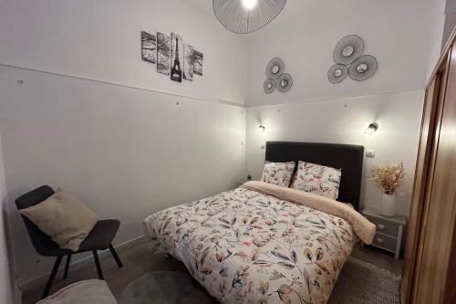 a bedroom with a bed and a chair at Le jardin privatif de Pauze Cauterets wifi et parking gratuits Vue panoramique in Cauterets