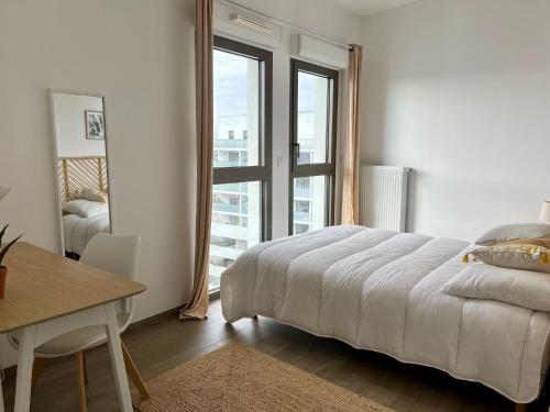 une chambre avec un lit, une table et une fenêtre dans l'établissement Appartement proche de la gare - 80m2, à Bordeaux