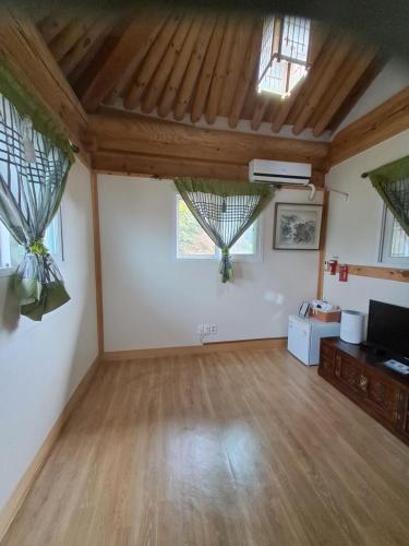 a living room with two windows and a wooden floor at Gyodong Gaon in Jeonju