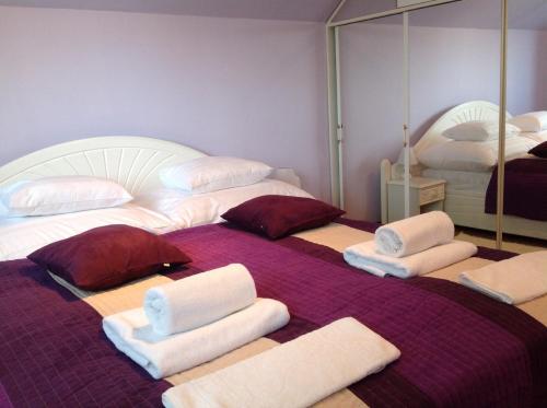 ヘーヴィーズにあるAttila Apartmanházのベッド2台、タオル、鏡が備わる客室です。