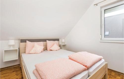a white bedroom with pink pillows on a bed at Two-Bedroom Apartment In Ogulin in Jasenak