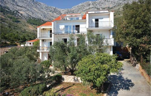 a white building with trees in front of a mountain at Apartment Ivan Dolac With Sea View Xii in Ivan Dolac
