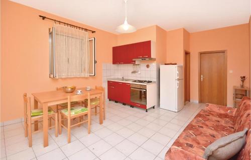 a kitchen with a table and a white refrigerator at Apartment Ivan Dolac With Sea View Xii in Ivan Dolac