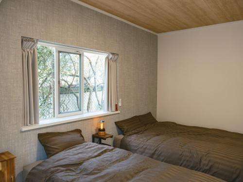 a bedroom with two beds and a window at サードプレイス百島 in Onomichi