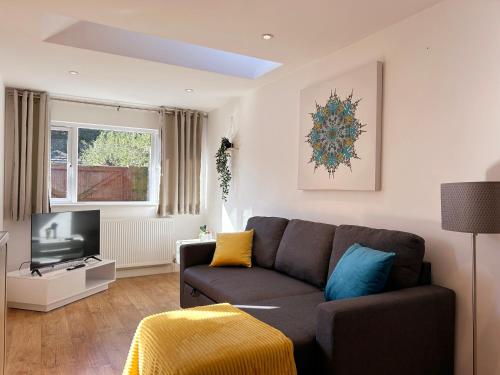 a living room with a couch and a television at Stylish 1 Bedroom Flat with Parking in Oxford in Oxford