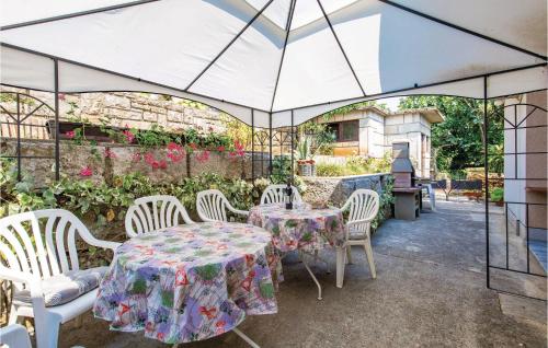 une terrasse avec une table et des chaises sous une tente dans l'établissement 3 Bedroom Stunning Apartment In Lovran, à Lovran