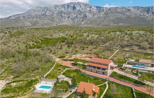 an aerial view of a house with a mountain in the background at Two-Bedroom Holiday Home In Kijevo in Kijevo