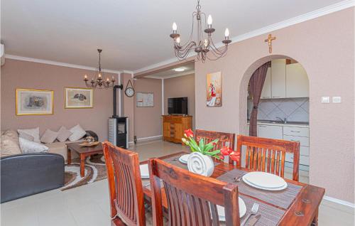 a dining room and living room with a table and chairs at Two-Bedroom Holiday Home In Kijevo in Kijevo