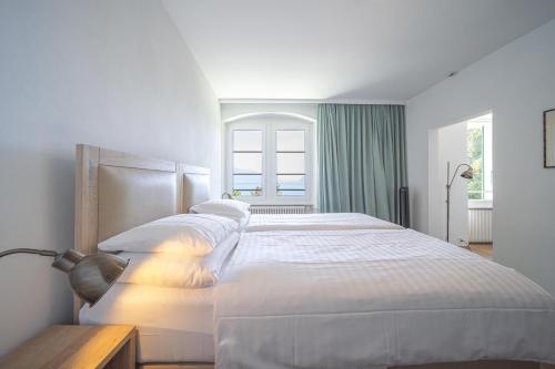 a bedroom with a large white bed with a window at Au Major Davel in Cully