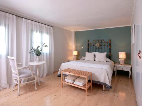 a bedroom with a bed and a table and a chair at Mythos Suites Boutique Hotel in Rethymno