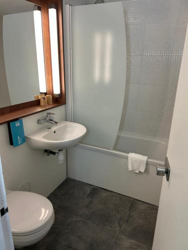 a bathroom with a sink and a toilet and a shower at Kyriad Direct Metz Nord – Woippy in Woippy