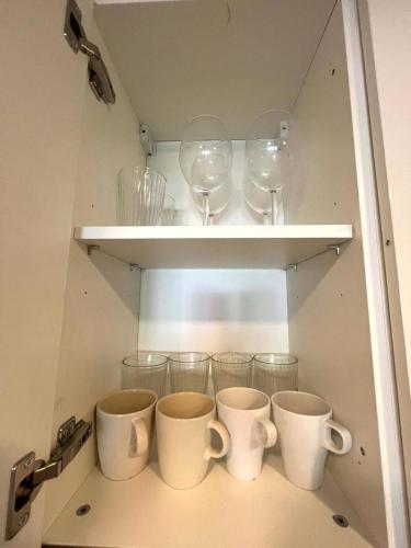 a cupboard with cups and wine glasses on it at Mykonos Hua Hin - 1 bdr Condo Shared Pool Downtown in Hua Hin