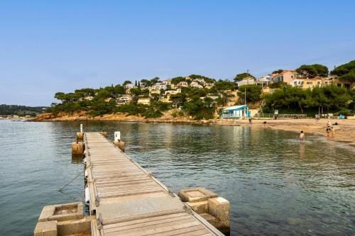 a dock on a body of water with houses at chambre d'hote luxe vue mer boheme in Le Pradet