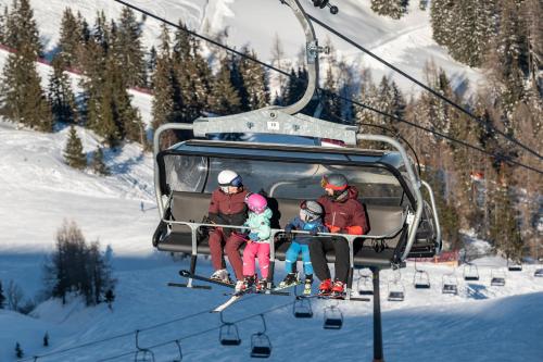 a group of people sitting on a ski lift at Naturhotel Hüttenwirt im Grossarltal in Hüttschlag