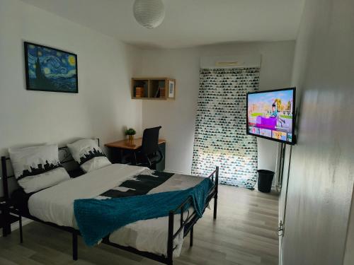 a bedroom with a bed and a flat screen tv at Chambre privée proche stade de France et Paris dans appartement partagé in Pierrefitte-sur-Seine