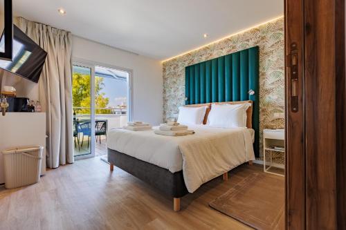 a bedroom with a large bed with a green headboard at The Palm Suites - Adults Only in Limassol
