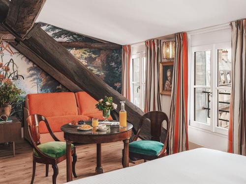 a living room with a table and a couch at Hotel Madeleine De Senlis in Paris