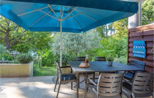 a blue table and chairs under a blue umbrella at Gorgeous Apartment In Njivice With Wifi in Njivice