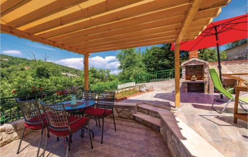a patio with a table and chairs and an umbrella at Beautiful Home In Golovik With Wifi in Martina