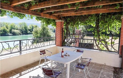 a table and chairs on a balcony with a view of a river at Apt A in Jaulgonne