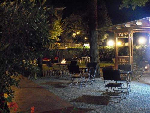 a patio with tables and chairs at night at Hotel Storyville - svago e convenzioni aziendali in Cinquale
