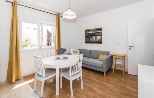 a living room with a table and a couch at Three-Bedroom Apartment In Rogoznica in Rogoznica