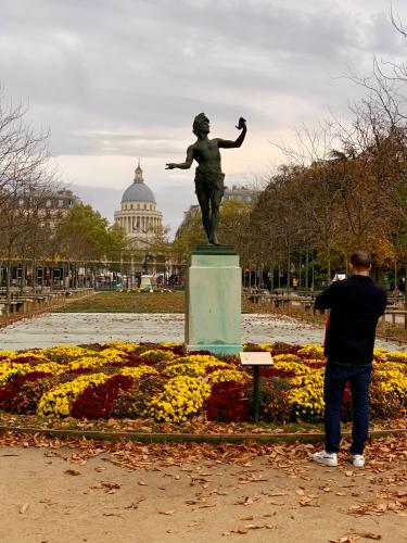 un homme prenant une photo d'une statue dans un parc dans l'établissement Studio entièrement rénové au cœur de Paris, à Paris