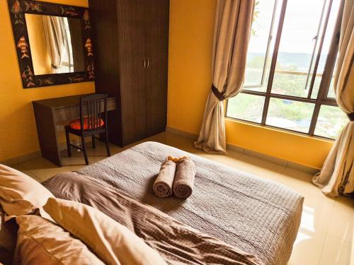 a bedroom with two towels on a bed with a window at Mossy Forest Family Retreat III, 2-8pax, Sunrise View, Cameron Highlands in Cameron Highlands