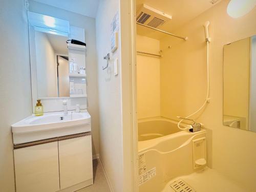a bathroom with a sink and a tub and a toilet at Hotel Arashi Nambaminami No003 in Osaka