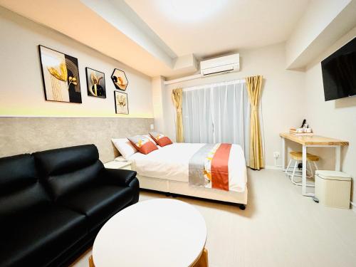 a hotel room with a bed and a couch at Hotel Arashi Nambaminami No003 in Osaka