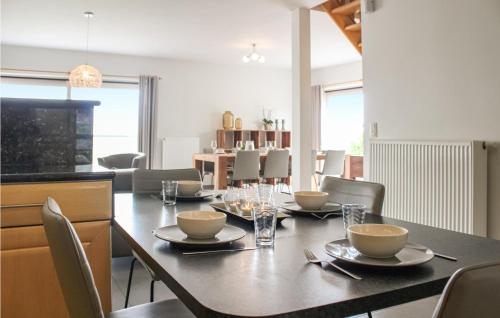 a dining room with a table with plates and bowls at Awesome Home In Diksmuide in Diksmuide