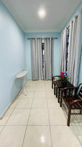 a living room with benches and blue walls at Bella Homestay in Kampong Bari Kechil