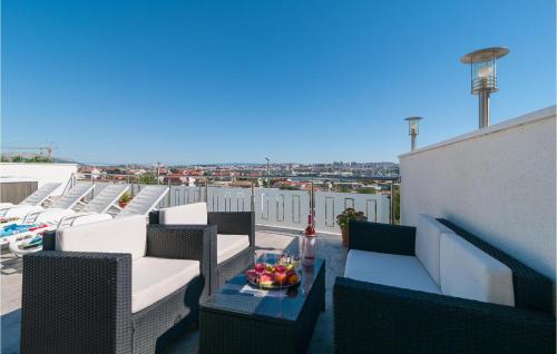 索林Studio Apartment In Solin的阳台配有椅子和一张桌子及一碗水果