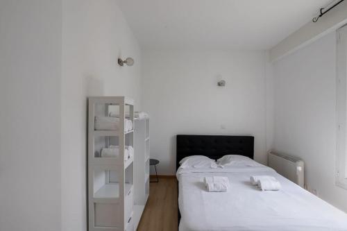 - une chambre blanche avec un lit et une étagère dans l'établissement Clichy New Flat 15 Min from Paris , Ideal for 4 Guests, à Clichy