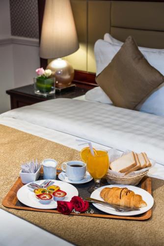 a tray with breakfast foods on a bed at Boudl Abha in Abha