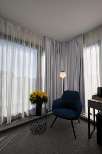 a living room with a blue chair and a table at Bizarre Boutique Hotel in Varna City