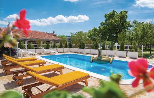 a swimming pool with lounge chairs and a pool slide at Nice Home In Unesic With Wifi in Unešić