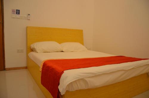 a bed with a wooden headboard in a room at PRIV Fodhdhoo in Fodhdhoo
