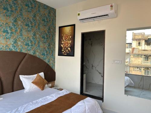a bedroom with a bed and a window at Hotel Shivay in Indore