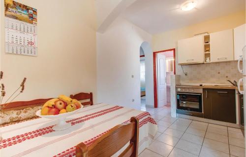 a kitchen with a bowl of fruit on a table at 2 Bedroom Nice Apartment In Mali Losinj in Mali Lošinj