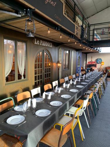 une longue table dans une pièce avec des chaises et des tables dans l'établissement Le Vintage Loft Garage, à Saint-Agnan-sur-Loire