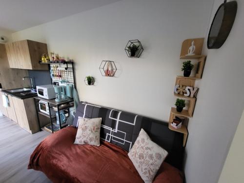 a living room with a bed and a kitchen at NATIBOXflo in Saint-Michel-de-Chavaignes