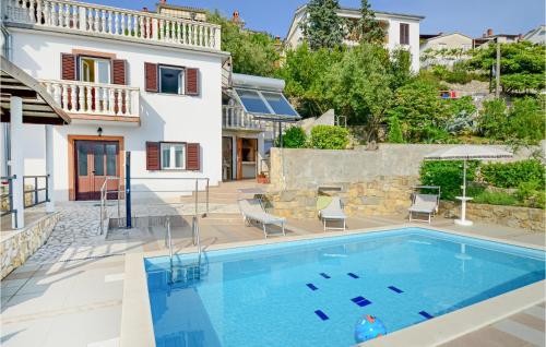 a villa with a swimming pool and a house at 4 Bedroom Beautiful Home In Rabac in Rabac