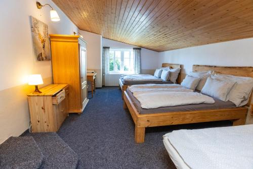 a bedroom with two beds and a wooden ceiling at Belvederská chalupa in Železná Ruda