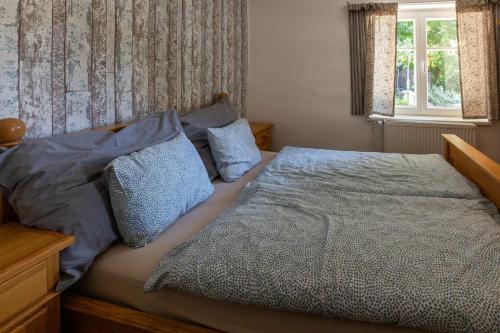 a bedroom with a large bed with blue pillows at Belvederská chalupa in Železná Ruda