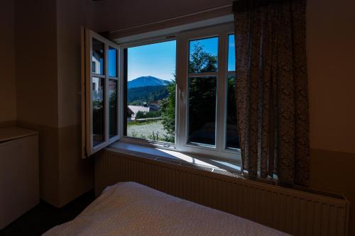 a bedroom with a window with a view of a mountain at Belvederská chalupa in Železná Ruda
